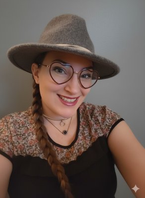 Image of a female presenting person in a hat with heart glasses.