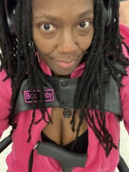Pretty Brown Girl with locs in leather vest and pink shirt