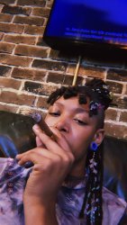 picture brown skin women with curly locs holding a cigar